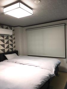 金沢市にあるKulton モースト 兼六のベッドルーム(大きな白いベッド1台、プロジェクションスクリーン付)