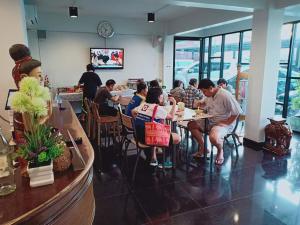 a group of people sitting at tables in a restaurant at บ้านเลขที่ 3 in Phitsanulok