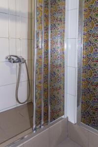 y baño con ducha y puerta de cristal. en AHOSTEL, en Yekaterinburg