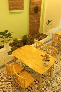 una mesa de madera y sillas en una habitación en Lam Garden Boutique Homestay, en Hue
