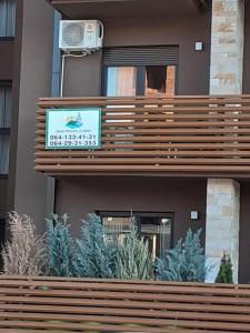 a sign on the side of a building with plants at Apartman Lukić in Zlatibor