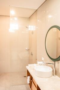 a bathroom with a sink and a mirror at Apple Villa & Suite Seminyak in Seminyak