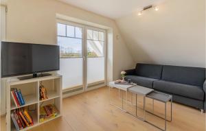 sala de estar con sofá azul y TV en Lovely Apartment In Langenhorn With House A Panoramic View, en Langenhorn