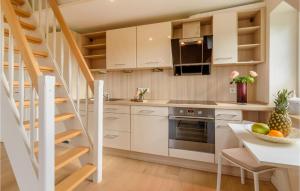 una cocina con armarios blancos y una escalera de caracol en Lovely Apartment In Langenhorn With House A Panoramic View, en Langenhorn