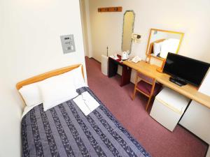 Habitación con cama, escritorio y espejo. en Hotel Royal Garden Kisarazu, en Kisarazu