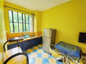 a kitchen with a refrigerator and a table and a sink at Blooms Apartments in Pereybere