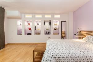 biała sypialnia z łóżkiem i półkami w obiekcie LF PARKING INCLUIDO Amplio Loft en Barrio Santa Cruz w Sewilli