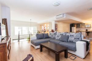 salon z kanapą i stołem w obiekcie LF PARKING INCLUIDO Amplio Loft en Barrio Santa Cruz w Sewilli