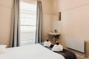 a bedroom with a bed and a sink and a mirror at Port Macquarie Hotel in Port Macquarie