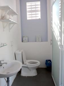 a white bathroom with a toilet and a sink at Summer Stations Homestay Binh Chau - Ho Coc Beach - Vung Tau in Xuyên Mộc