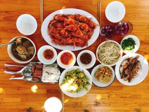 a table with plates of food and bowls of food at Summer Stations Homestay Binh Chau - Ho Coc Beach - Vung Tau in Xuyên Mộc