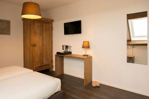 - une chambre avec un lit et une table avec une lampe dans l'établissement Hoevehotel 'Hof Christina', à Vrouwenpolder