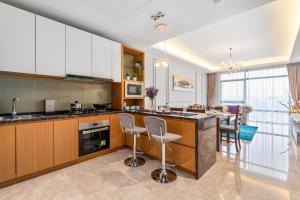 a kitchen with wooden cabinets and a bar with stools at Anggun Residences Serviced Suites in Kuala Lumpur