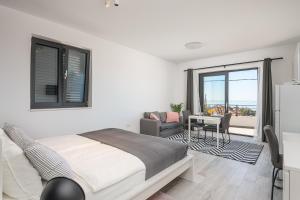 ein Schlafzimmer mit einem Bett und ein Wohnzimmer mit einem Fenster in der Unterkunft Lemon Tree Dubrovnik Apartments in Dubrovnik