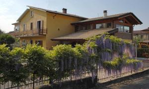een huis achter een hek met paarse bloemen bij Elena Appartamento in Peschiera del Garda