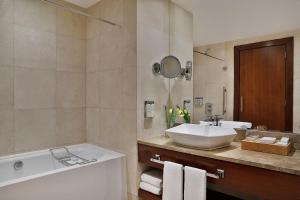 a bathroom with a tub and a sink and a bath tub at voco Dubai, an IHG Hotel in Dubai