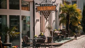 a restaurant with tables and chairs in front of a building at Hotel Traubenwirt in Marlengo