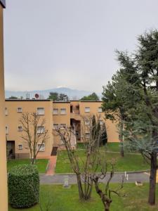 a view of a building with trees in the foreground at Sweet Appartment di Guido in Peschiera del Garda