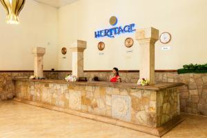 a woman standing behind a counter in a hotel lobby at Heritage Hotel in Anuradhapura