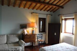 a bedroom with a couch and a bed and a window at Villarondanella in Fermo