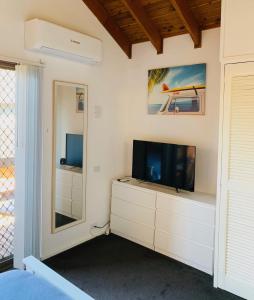 ein Schlafzimmer mit einem Flachbild-TV auf einer Kommode in der Unterkunft Central Tranquility in Orange