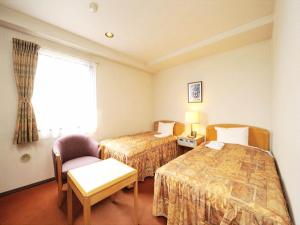 Habitación de hotel con 2 camas, silla y ventana en Hotel Royal Garden Kisarazu, en Kisarazu