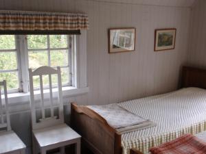 1 dormitorio con 1 cama y 2 ventanas en Skyarp Villan en Håcksvik