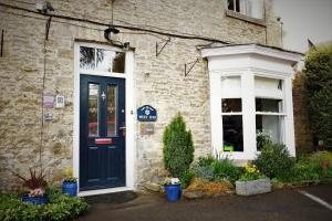 a brick house with a blue door and a window at West End Guest House in Richmond