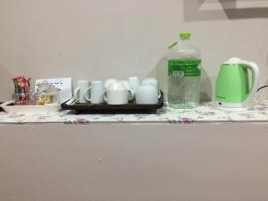 a table with cups and a bottle of water on it at SMILE HOME GUESTHOUSE in Rayong
