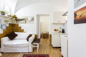 a living room with a white couch and a kitchen at Palermo Central Holiday in Palermo