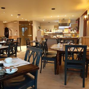 een eetkamer met tafels en stoelen in een restaurant bij Hotel Rubens in Oostende
