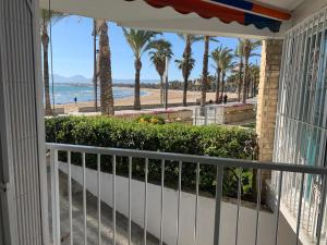 a balcony with a view of the beach and palm trees at Bello Horizonte Frontbeach in Salou