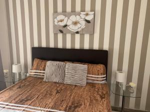 a bedroom with a bed and a striped wall at Bello Horizonte Frontbeach in Salou