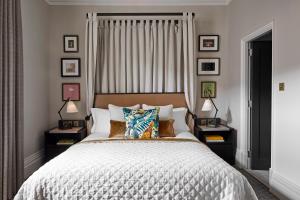 a bed with a white comforter and pillows in a bedroom at Kimpton - Fitzroy London, an IHG Hotel in London