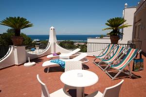 d'une terrasse avec des chaises et des tables et une vue sur l'océan. dans l'établissement Hotel Casa Di Meglio, à Ischia