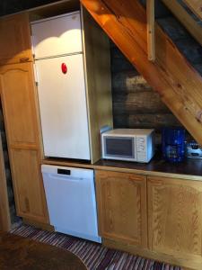 a white refrigerator in a kitchen with a microwave at Kelola Cottage in Keyritty