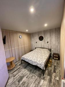 Schlafzimmer mit einem Bett und Holzboden in der Unterkunft Constancia in Kamjanez-Podilskyj