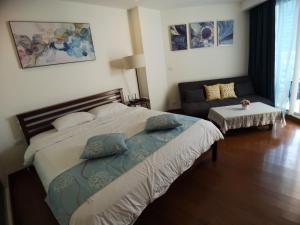 a bedroom with a large bed and a couch at The palm wongamat pattaya in Pattaya North