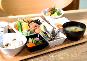 a tray of food on a table with bowls of food at Daiwa Roynet Hotel Chiba-chuo in Chiba
