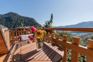 a vase of flowers sitting on a table on a balcony at Glamping Tinka in Tolmin