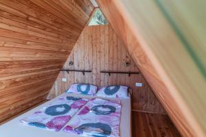 Bett in einem hölzernen Zimmer mit Dach in der Unterkunft Glamping Tinka in Tolmin