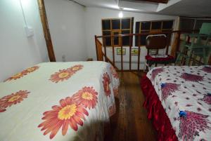 een slaapkamer met twee bedden met bloemen erop bij Cusco Centro Histórico Dept. Ruth in Cuzco
