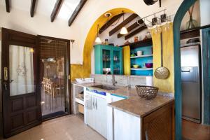 eine Küche mit blauen und grünen Schränken und einem Waschbecken in der Unterkunft Casa Madre Tierra con jacuzzi piscina zona de barbacoa y preciosas vistas in Cómpeta