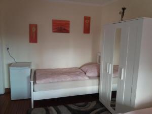 a small bedroom with a bed and a cabinet at Pensionszimmer Lützowzimmer in Lübeck