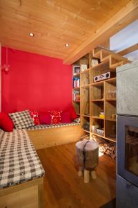 uma sala de estar com uma parede vermelha e um sofá em Stadel Ritz em Niederwald