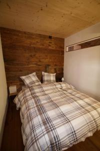 a bed in a room with a wooden wall at Stadel Ritz in Niederwald