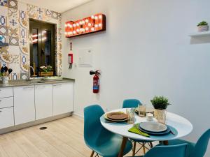 a kitchen with a white table and blue chairs at Family Hostel Costa Nova in Costa Nova
