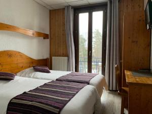 Un pat sau paturi într-o cameră la Hotel des Lacs