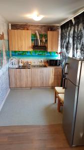 una cucina con armadi in legno e frigorifero in acciaio inossidabile di Apartment 9 floor a Narva