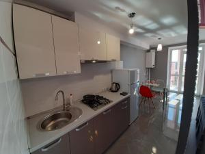 a small kitchen with a sink and a stove at Стильна квартира-студія в центрі міста на набережній in Ternopilʼ